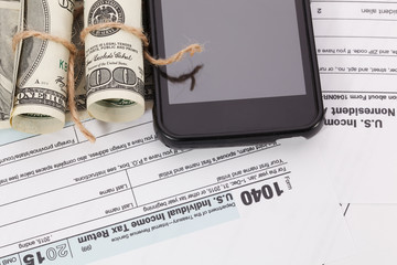 Money and cellphone on tax form background