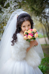 fiancee brunette in a wedding-dress with a bouquet