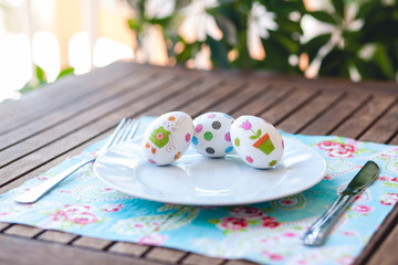 White plate and easter eggs on wood table