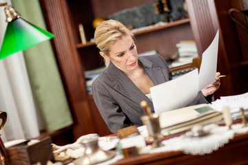 businesswoman sitting at a table in the office and working