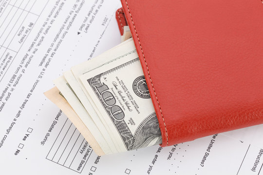 Money in Wallet on tax form background