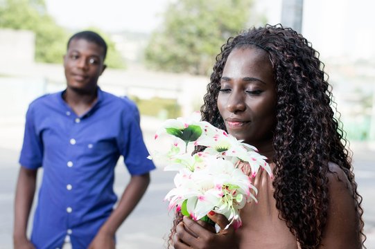 Young woman enjoying a flower with love.