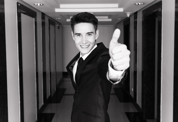 Young businessman with thumbs up.