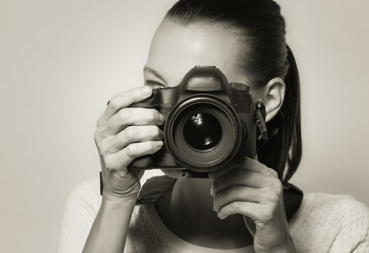 Female using DSLR camera.