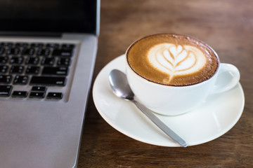 hot latte and laptop on table