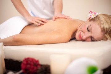 Obraz na płótnie Canvas Woman getting recreation massage in spa salon