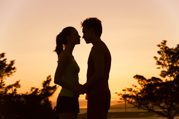 Couple kissing at sunset.  - obrazy, fototapety, plakaty