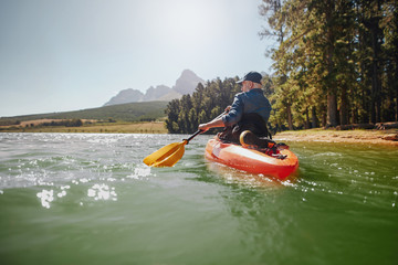 Senior man paddling kayak on a summer day