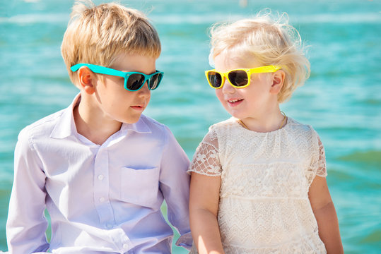 Cute little girl and boy wearing sunglasses and smiling