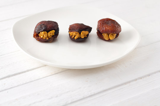 traditional Eastern dessert - Hashtak (apricots with walnuts) on a white plate