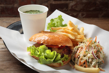 The food with soup, burger and salad on a tray with white paper