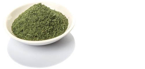 Dried dill herbs in white bowl over white background