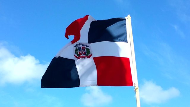 Domenican republic flag wining in the wind, at the beach of punta cana