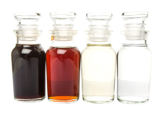 Vinegar, balsamic vinegar, maple vinegar and apple vinegar in glass vial over white background