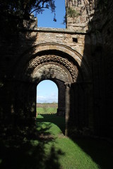 Abbey ruins archway in shadows and sunlight