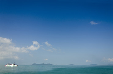 calm sea with lonely boat and blue sky background