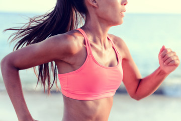Cardio running workout - Upper body closeup crop of unrecognizable woman runner in fast motion showing pink sports bra activewear clothing in ocean beach nature background. - Powered by Adobe