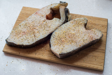 the halibut steak on a chopping Board