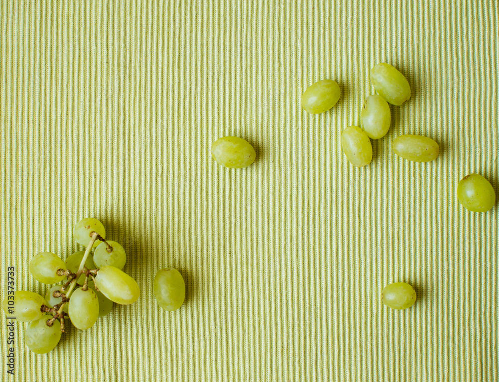 Wall mural green grapes on a green textured tablecloth