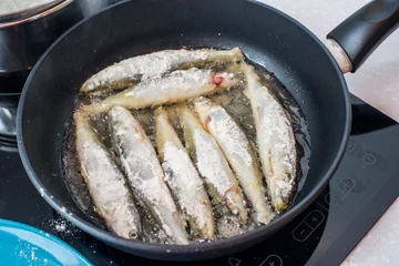 Deurstickers Fried small smelt tasty fish on a barbecue  hotplate © suvorovalex