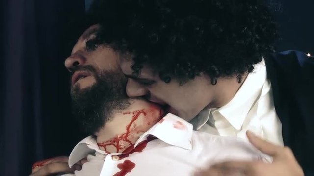 Vampire biting with fangs young man