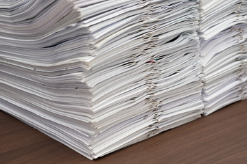 Pile of documents with clips on desk stack up