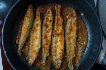 Fried small smelt tasty fish on a barbecue  hotplate