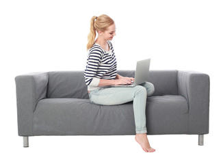 Obraz premium a pretty blonde lady wearing casual clothes, lounging on a grey sofa. isolated on a white background.