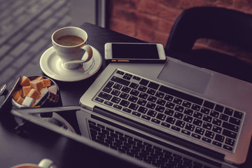 A laptop's keyboard and a cup of coffee.
