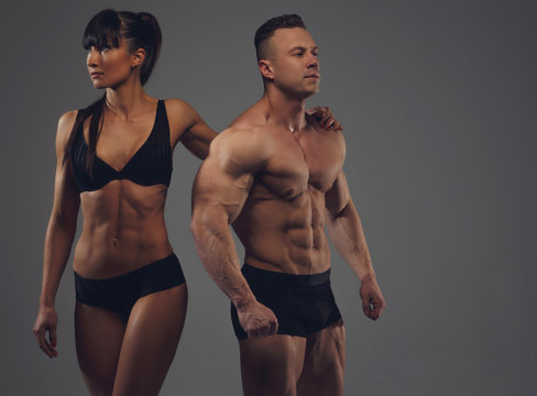 Fitness couple isolated on a grey background.