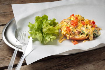 The meals with a salad and a sandwich with egg on a tray