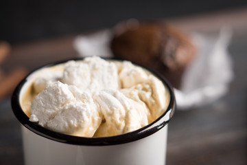 Cup of hot cocoa with marshmallows and chocolate muffins on the dark rustic wooden background