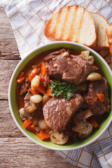 Rustic Beef Bourguignon in a bowl on a table close-up. vertical top view
