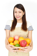 果物を持つ笑顔の女性 