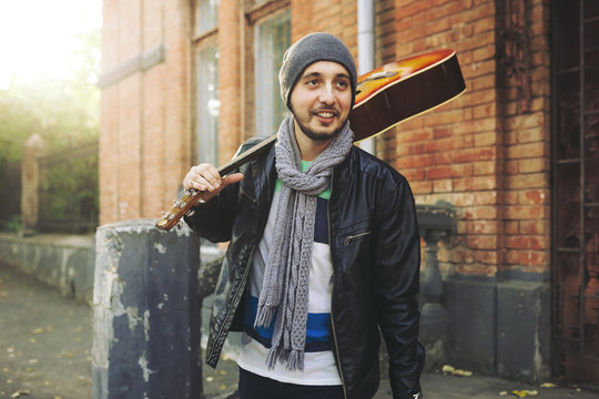 Young attractive street artist with his guitar