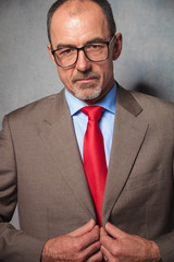 bald businessman wearing glasses posing in studio background