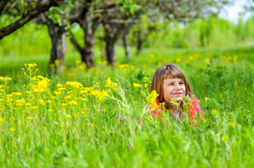 little girl lying on the grass in spring