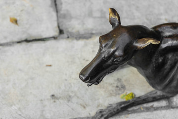 bronze dog statue crouch on brick floor