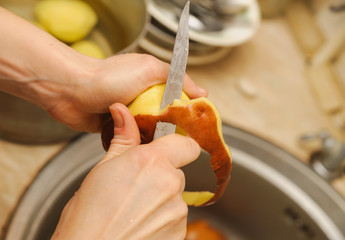 Woman cutting to peel potatoes. Kitchen working. Prepare food