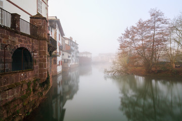 Reflections in the Baztan river with foggy and ocher colors in the trees, Elizondo, Navarra, Spain