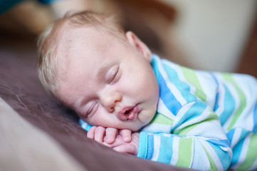 Little baby boy sleeping on his stomach in the bed
