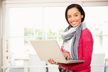 Smiling brunette using laptop