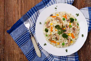 Classic Risotto with mushrooms and vegetables served on a white