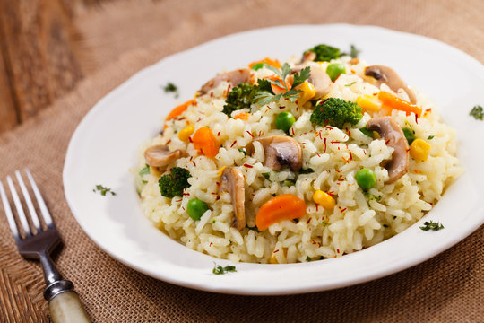 Classic Risotto with mushrooms and vegetables served on a white