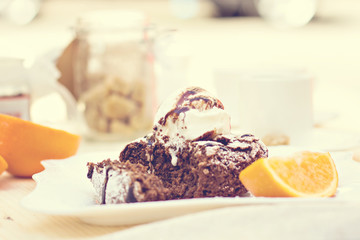 Warm dessert chocolate cake Fondant served on plate with ice-cream ball, almond chips, mint, icing, citron, cacao