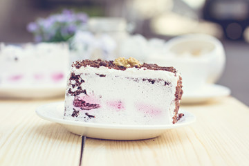 Delicious chocolate cake on plate on table on light background. Tonned photo.