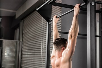 Shirtless man doing pull up