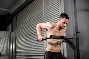 Obraz premium Shirtless man doing pull up