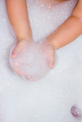 Fototapeta premium clean baby hands with soap foam washing 