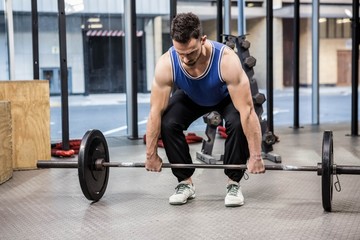 Muscular man lifting barbell